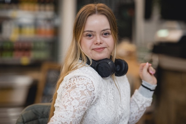 woman smiling at camera with headphones